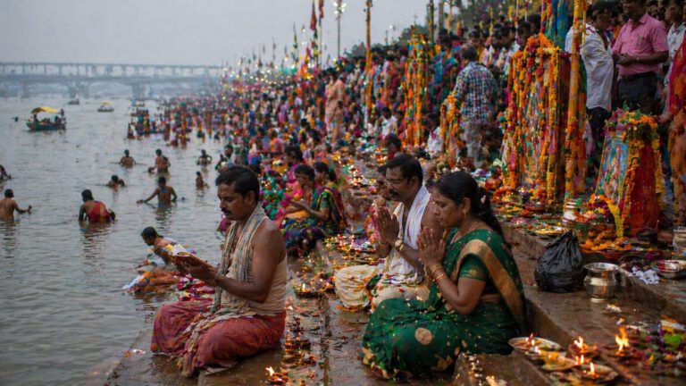 Devotees performing puja with marigolds at Saraswati Ghat